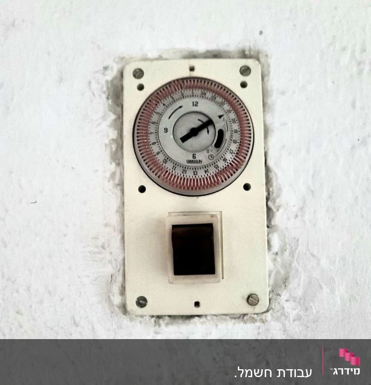 שעון טיימר חשמלי מותקן על קיר לבן